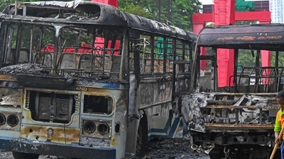A worker sweeps the street alongside the burnt buses near Sri Lanka's former prime minister Mahinda Rajapaksa's official residence 'Temple Trees', a day after they were torched by protesters in Colombo on May 10, 2022. (Photo by ISHARA S. KODIKARA / AFP) A worker sweeps the street alongside the burnt buses near Sri Lanka's former prime minister Mahinda Rajapaksa's official residence 'Temple Trees', a day after they were torched by protesters in Colombo on May 10, 2022. (Photo by ISHARA S. KODIKARA / AFP)