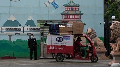 A delivery man passes through the entrance to a community in Beijing. (AP)