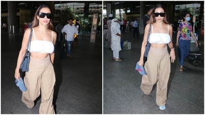 Malaika teamed the spaghetti-strapped crop top with a pair of beige pants featuring a high-rise waistline, double buttons, flared hem, and pleats to give a structured fall. She added a dash of colour to the neutral palette by pairing the get up with blue, pink and white coloured chunky lace-up sneakers. (HT Photo/Varinder Chawla)