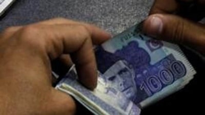 A currency trader counts Pakistani rupee notes as he prepares an exchange of US dollars in Islamabad, Pakistan. (Reuters File Photo)