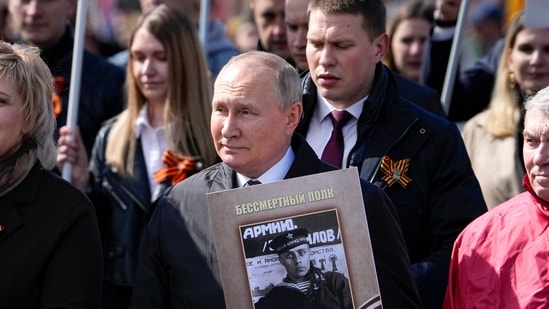 Russian President Vladimir Putin, center, attends the Immortal Regiment march through Red Square marking the 77th anniversary of the end of World War II, in Moscow, Russia, Monday, May 9, 2022.(AP)