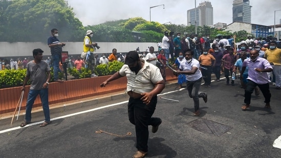 Demonstrators and government supporters clash outside the official residence of Sri Lanka's Prime Minister Mahinda Rajapaksa, in Colombo.(AFP)