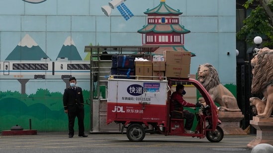 A delivery man passes through the entrance to a community in Beijing.(AP)