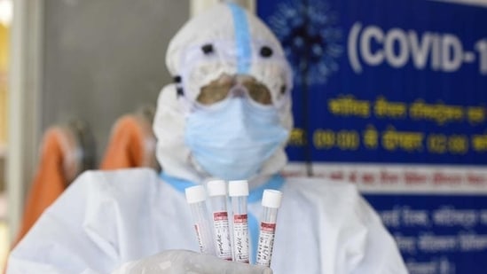 A health worker shows the collected swab sample for RT-PCR for coronavirus test at the Ayushman Bharat Health and Wellness Centre in Gurugram. (Parveen Kumar/HT Photo)