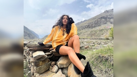 Bhumi Pednekar posed in her comfy stylish clothes in front of a picturesque backdrop with snow-capped mountains and a lake.(Instagram/@bhumipednekar)