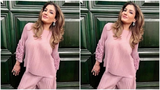 Raveena paired a shimmery satin pastel pink top with a pair of pastel pink trousers.(Instagram/@officialraveenatandon)