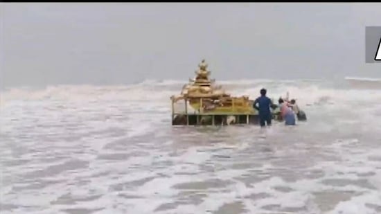 A video tweeted by agency ANI showed people on the shore dragging the chariot out of the water and bringing it to the shore.