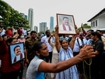 Pro-government supporters hold Prime Minister Mahinda Rajapaksa's portrait while protesting outside the prime minister�s residence in Colombo. Pro-government supporters hold Prime Minister Mahinda Rajapaksa's portrait while protesting outside the prime minister�s residence in Colombo.