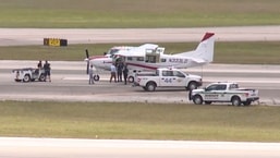 In this still image from video by WPTV shows emergency personnel surrounding a Cessna plane at Palm Beach International Airport Tuesday.
