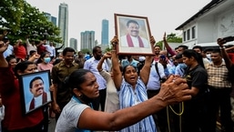 Apoiadores pró-governo seguram o retrato do primeiro-ministro Mahinda Rajapaksa enquanto protestam do lado de fora da residência do primeiro-ministro em Colombo.
