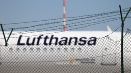 A Lufthansa jet is seen behind a barbed-wire fence at the airport&nbsp;