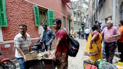 Residents carry their belonging as they leave their houses after their houses developed cracks amid the ongoing metro-rail construction at Durga Pithuri lane, Bowbazar, in Kolkata on Thursday. (ANI) Residents carry their belonging as they leave their houses after their houses developed cracks amid the ongoing metro-rail construction at Durga Pithuri lane, Bowbazar, in Kolkata on Thursday. (ANI)