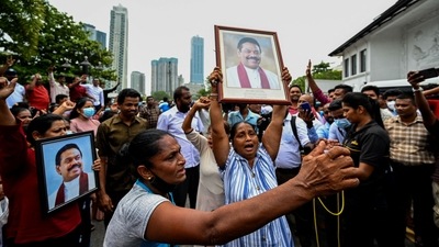 Pro-government supporters hold Prime Minister Mahinda Rajapaksa's portrait while protesting outside the prime minister�s residence in Colombo. (AFP)