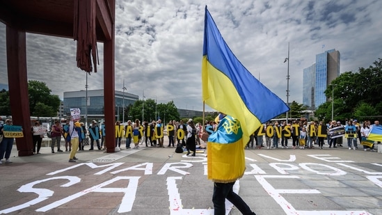 TOPSHOT - Ukrainians stage a protest outside of the United Nations Office during special session of the UN Human Rights Council on the war in Ukraine, in Geneva on May 12, 2022. - Ukraine slams what it calls the "sheer horror" and "pure evil" being inflicted on their country by Russian forces as the United Nations Human Rights Council holds an extraordinary session on Ukraine. (Photo by Fabrice COFFRINI / AFP)(AFP)