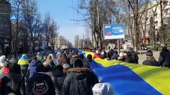 FILE PHOTO: Live-streamed footage shows people carrying a banner in the colours of the Ukrainian flag as they protest amid Russia's invasion of Ukraine, in Kherson, Ukraine in March.&nbsp;(via REUTERS)