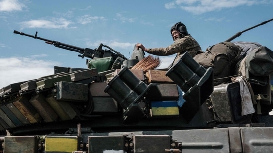 A Ukrainian soldier sits on a tank carryied by a transporter near Bakhmut, eastern Ukraine, on May 12, 2022.