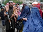Women walk through the old market as a Taliban fighter stands guard, in the city of Kabul, Afghanistan, Women walk through the old market as a Taliban fighter stands guard, in the city of Kabul, Afghanistan,