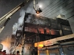 Firefighters try to douse a fire which broke out in a building at Mundka, in West Delhi on Friday.