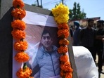 Photograph of slain Kashmiri pandit and government employee Rahul Bhat is seen during a protest against his killing on the outskirts of Srinagar. Photograph of slain Kashmiri pandit and government employee Rahul Bhat is seen during a protest against his killing on the outskirts of Srinagar.
