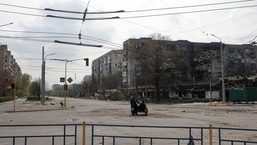 FILE PHOTO: Local residents ride a motorcycle along an empty street with residential buildings damaged by a military strike, as Russia's attack on Ukraine continues, in Sievierodonetsk, Luhansk region.&nbsp;