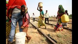 Villagers carry empty containers as they walk to fetch water from an abandoned stone quarry on a hot weather day in Badama village in Uttar Pradesh, recently. (REUTERS)