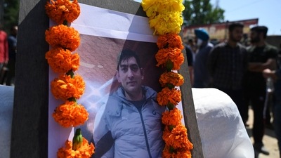 Photograph of slain Kashmiri pandit and government employee Rahul Bhat is seen during a protest against his killing on the outskirts of Srinagar. (AFP)