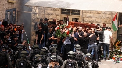 Family and friends carry the coffin of Al Jazeera reporter Shireen Abu Akleh, who was killed during an Israeli raid in Jenin in the occupied West Bank, next to Israeli security forces, during her funeral in Jerusalem. (REUTERS)