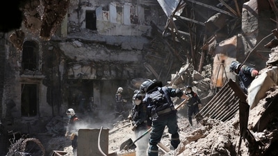 Rescue employees clear rubble at the side of the damaged theatre in Mariupol. (AP) Rescue employees clear rubble at the side of the damaged theatre in Mariupol. (AP)