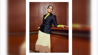 The outfit is a set of a yellow turtle neck, a yellow & beige asymmetric pleated skirt and a black blazer. (Instagram/@sukritigrover) The outfit is a set of a yellow turtle neck, a yellow & beige asymmetric pleated skirt and a black blazer. (Instagram/@sukritigrover)