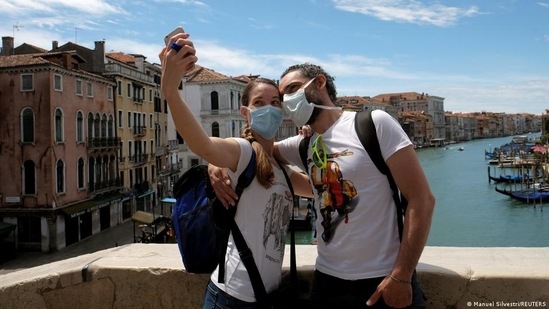 Vacations are possible in Europe — but certain rules, like wearing masks, are still in place in many countires.(Manuel Silvestri/REUTERS )