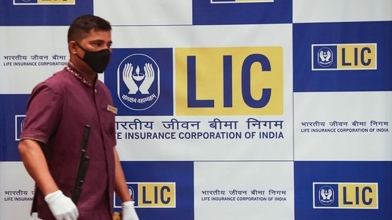 A man walks past a hoarding of Life Insurance Corporation of India (LIC) in Mumbai.(Reuters file)