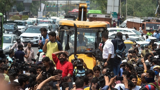 Locals stage a protest in front of an MCD bulldozer at Shaheen Bagh area during an anti-encroachment drive, in New Delhi, on Monday.(PTI)