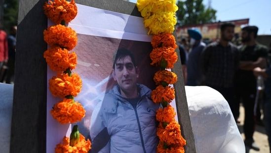 Photograph of slain Kashmiri pandit and government employee Rahul Bhat is seen during a protest against his killing on the outskirts of Srinagar.(AFP)