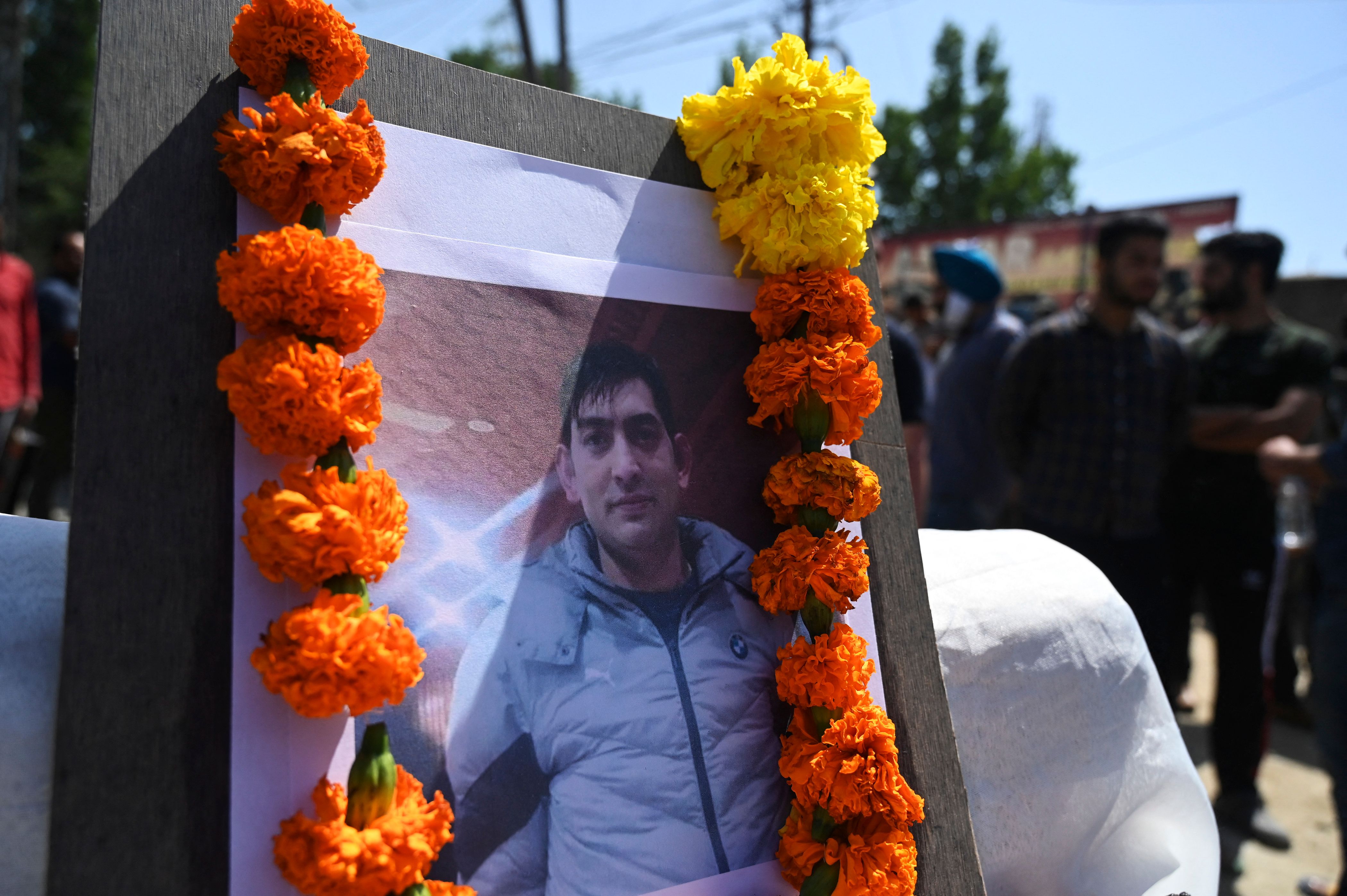 Photograph of slain Kashmiri pandit and government employee Rahul Bhat is seen during a protest against his killing on the outskirts of Srinagar. (AFP)