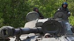 Membros do serviço de tropas pró-Rússia são vistos no topo de um obus autopropulsado nos arredores de Donetsk, na Ucrânia, em 13 de maio de 2022. 