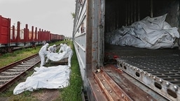 THE COST OF WAR: Ukrainian servicemen carry bodies of Russian soldiers killed during Russia's invasion, before putting them in a refrigerated rail car, in Kyiv.&nbsp;