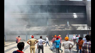 Police personnel and locals gather at the site, where a fire broke out in the Guru Nanak Dev Hospital, in Amritsar on Saturday. (PTI)