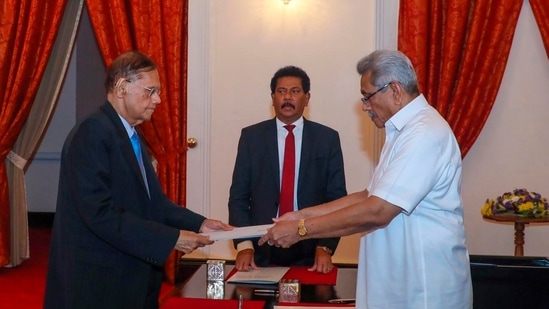 President Gotabaya Rajapaksa, right, hands over the appointment document to Gamini Lakshman Peiris after he took oath of office as the new foreign minister in Colombo. (AP)