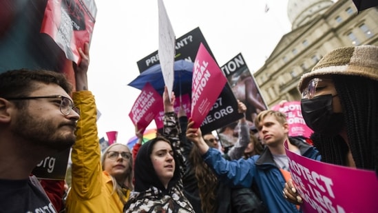 Abortion-rights advocates, right, try to block anti-abortion signage during a rally at the state capitol in Lansing, Michigan.(AP)