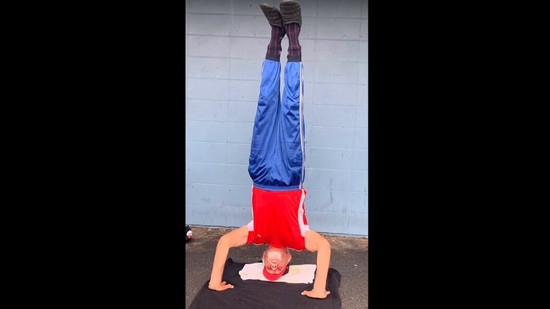 The image, taken from the Instagram video, shows the 75-year-old man performing a headstand for a world record.(Instagram/@guinnessworldrecords)