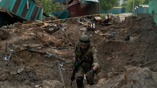 Um policial da força-tarefa especial inspeciona um local após um ataque aéreo das forças russas em Lysychansk, região de Luhansk, em 13 de maio de 2022. (AP)