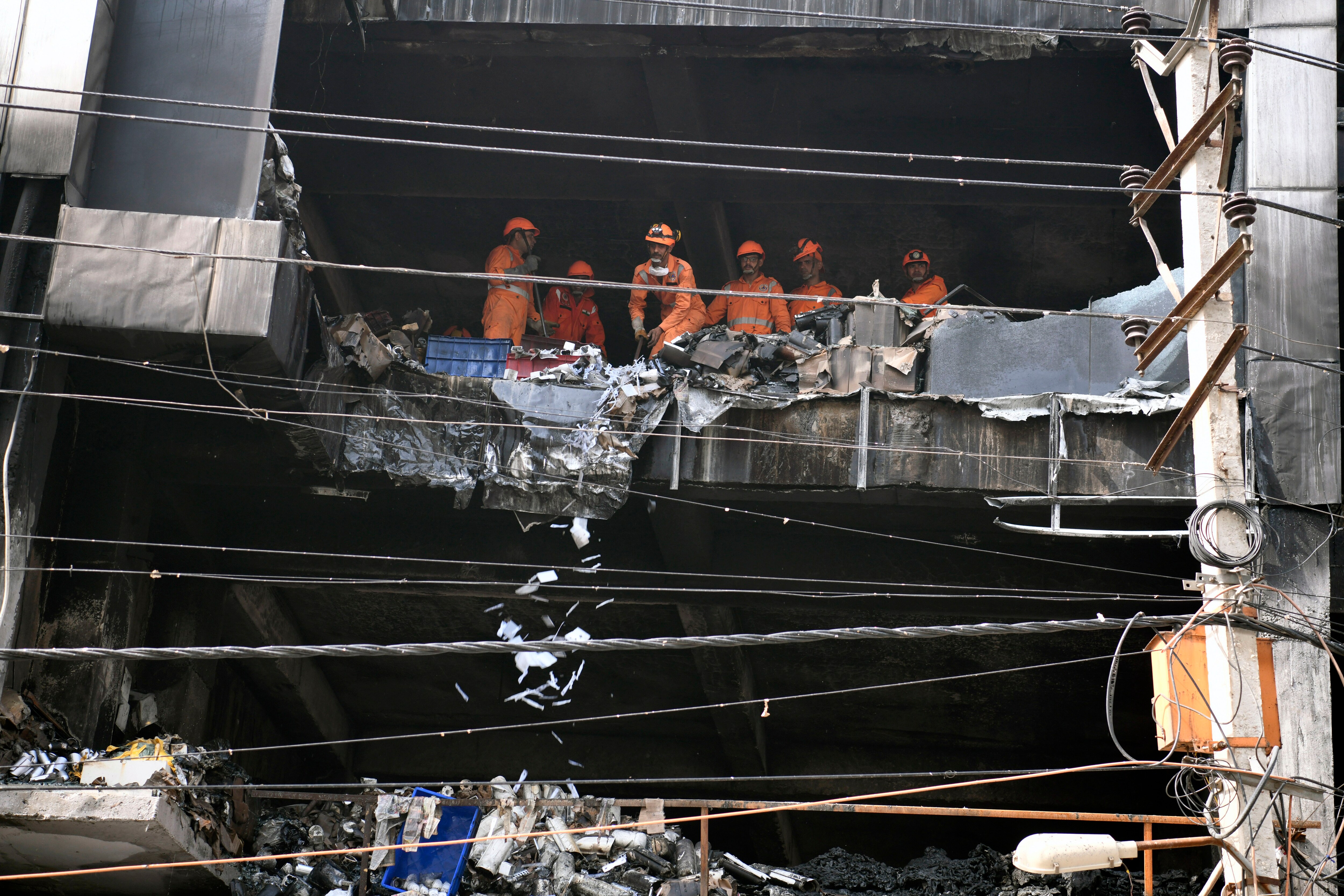 NDRF personnel carry out search and rescue operations at the building where a fire broke out that left at least 27 persons dead and 12 injured near Mundka Metro station, in Delhi on Saturday, May 14, 2022. (ANI Photo/Ishant Kumar)