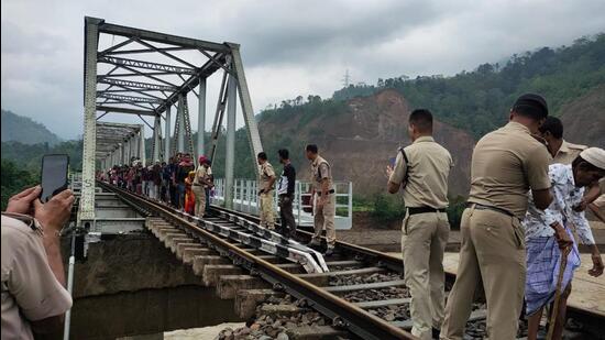 Stranded train passengers being helped so that they can cross a damaged railway bridge on foot at Ditokcherra in Assam. (Northeast Frontier Railway.)