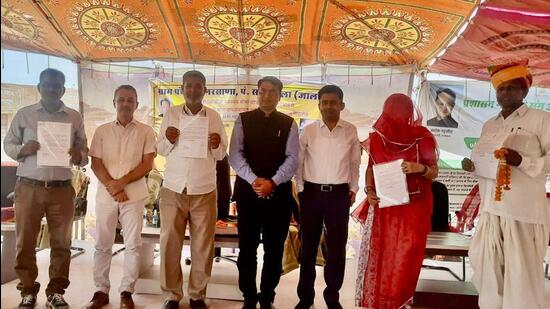 Jalore district collector Nishant Jain felicitating the donors, officials and others on achieving 100% health insurance coverage in Narsana.