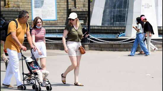 Tourists take a stroll on a hot sunny day on The Ridge in Shimla on Sunday. (Deepak Sansta/Hindustan Times)