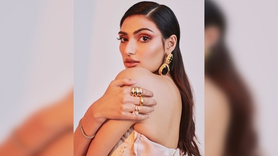 Athiya Shetty teamed her look with statement jewellery that comprises gold and black stoned earrings and multiple rings.(Instagram/@athiyashetty)