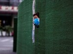A resident looks out through a gap in the barrier at a residential area during lockdown, amid the coronavirus disease (Covid-19) pandemic, in Shanghai, China.(REUTERS)