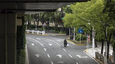A delivery worker rides a motorcycle rides along a near-empty road during a lockdown due to Covid-19 in Shanghai, China, on Monday. (Bloomberg) A delivery worker rides a motorcycle rides along a near-empty road during a lockdown due to Covid-19 in Shanghai, China, on Monday. (Bloomberg)