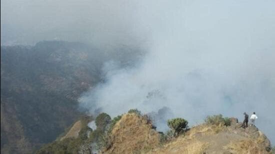 The tourist town of Kasauli in Solan district of Himachal Pradesh was engulfed in a plume of thick smoke billowing from the forest throughout Sunday as dry pine needles caught fire. (HT Photo)