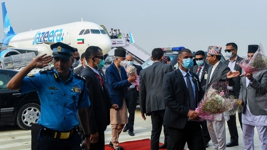 Nepal's Prime minister Sher Bahadur Deuba (C) is greeted by officials upon his arrival at the newly built Gautam Buddha International Airport following its inauguration in Siddharthanagar on May 16, 2022. &nbsp;(Photo by Prakash MATHEMA / AFP)